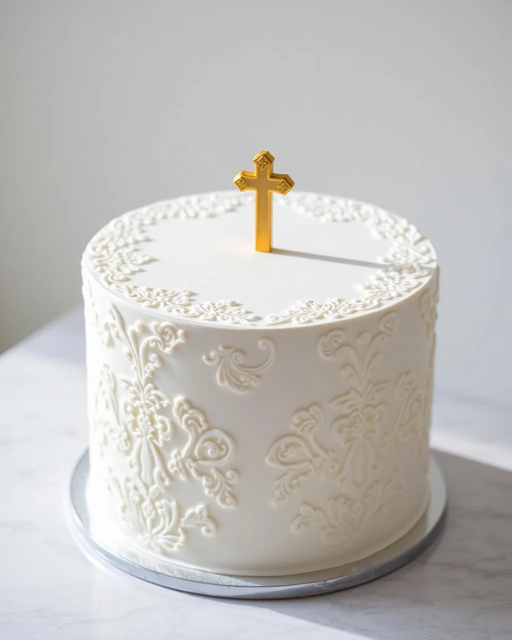 Gâteau de baptême blanc à dentelle de sucre avec petite croix dorée discrète.
